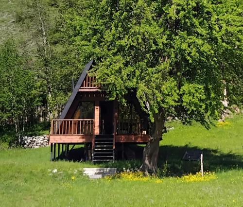 a tree house with a deck under a tree at Phaliani's Heaven in Mestia