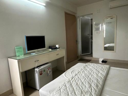 a bedroom with a bed and a television on a desk at Nhà Nghỉ Gia Anh in An Dương
