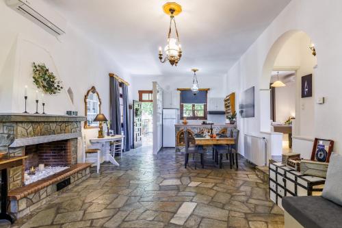 a living room with a fireplace and a dining room at Efcharis house Skopelos in Neo Klima