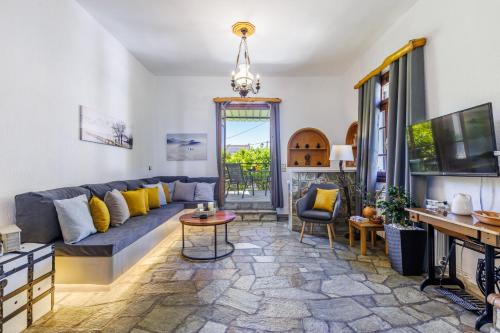 a living room with a couch and a tv at Efcharis house Skopelos in Neo Klima