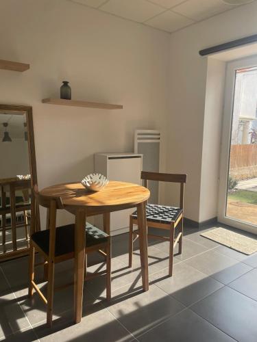 une cuisine avec une table en bois et deux chaises dans l'établissement Chez Ambre et Lulu - Appartement centre ville avec piscine, à Millau