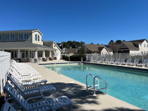 una piscina con tumbonas frente a una casa en Southport Condo near ICW and Golf - Dogs Allowed - Ground Level, en Southport