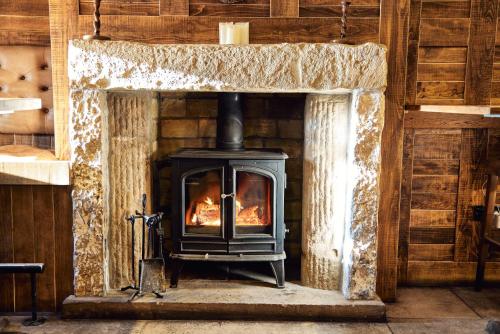 a wood stove in a fireplace in a room at Barley Mow in Burnley