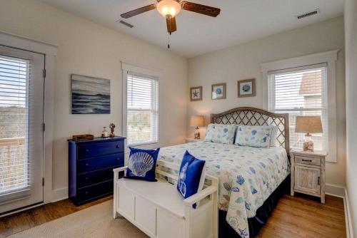 a bedroom with a bed and a dresser and windows at 2701- A S Shore Drive - Threefoot in Surf City