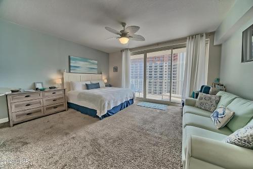 巴拿马城海滩Sunset at The Shores的一间带床、沙发和窗户的卧室