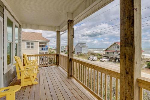 a porch with a yellow chair and a view of the ocean at 2701- A S Shore Drive - Threefoot in Surf City