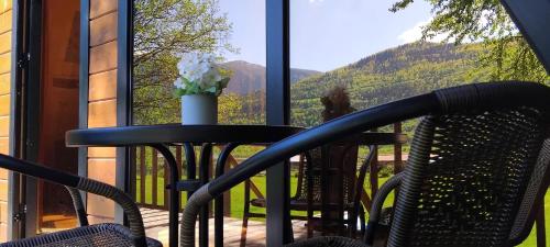 a table and chairs on a porch with a view of mountains at Phaliani's Heaven in Mestia
