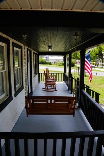 a porch with a bench and an american flag at 1939 Four Bed Rustic Escape by Casino in Ranson