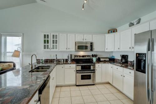 een keuken met witte kasten en roestvrijstalen apparaten bij 1906-B S Shore Drive - Beg T' Go in Watts Landing