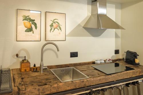 a kitchen with a sink and two pictures of fruit on the wall at Casa del Moro in Mercato Saraceno