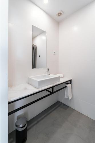 a white bathroom with a sink and a mirror at Marinhas Bed & Breakfast in Esposende