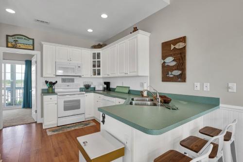 a kitchen with white cabinets and a green counter top at 3950 Island Drive in North Topsail Beach