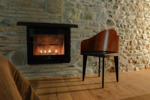 a chair sitting in front of a stone fireplace at Casa del Moro in Mercato Saraceno