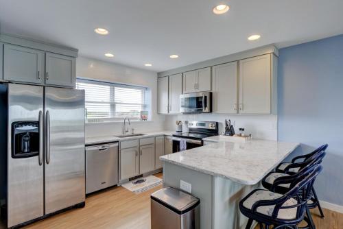a kitchen with a stainless steel refrigerator and cabinets at 3962 Island Drive - Here Comes The Sun in North Topsail Beach