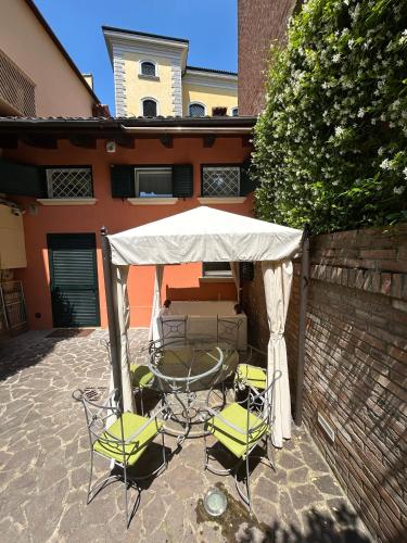 a table and chairs under a tent in front of a building at BolognaRoomscom - Isaia Garden Private Garden Spa Bath in Bologna
