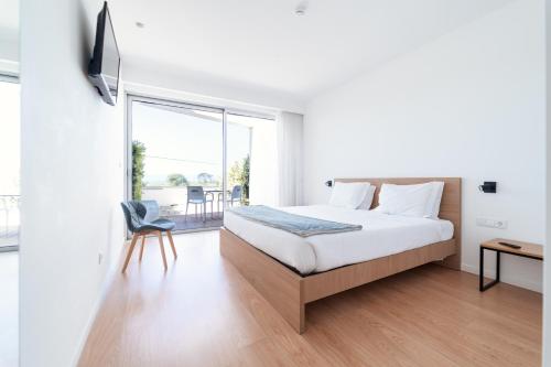 a bedroom with a bed and a large window at Marinhas Bed & Breakfast in Esposende
