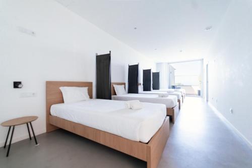 a row of beds in a room with white walls at Marinhas Bed & Breakfast in Esposende