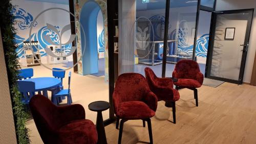 a group of red chairs sitting in a room at Pratum Plus prywatny ogród z tarasem grill leżaki in Mikołajki