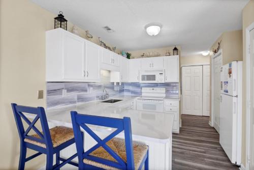 a kitchen with white cabinets and blue chairs at 3958 Island Drive in North Topsail Beach