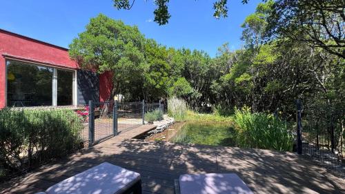 une cour arrière avec une clôture et un étang dans l'établissement La villa Nature au territoire du Pic Saint Loup, à Viols-le-Fort