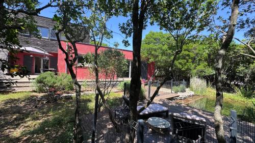 un banc devant une maison rouge dans l'établissement La villa Nature au territoire du Pic Saint Loup, à Viols-le-Fort