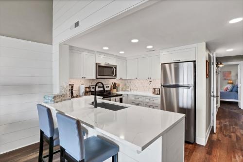 a kitchen with white cabinets and a stainless steel refrigerator at Surf Condos 737 in Surf City