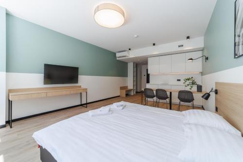 a bedroom with a white bed and two chairs at River Stay Apartments in Tallinn
