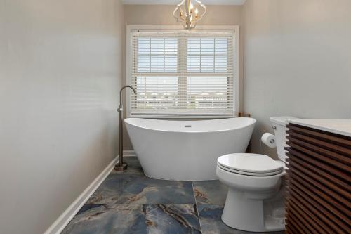 a bathroom with a tub and a toilet and a window at 3530 Island Drive in North Topsail Beach
