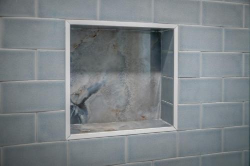 a blue tiled wall with a window in a bathroom at 3530 Island Drive in North Topsail Beach