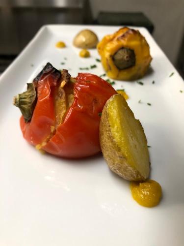 a white plate with a tomato and a lemon on it at Ca di Voi in Calizzano