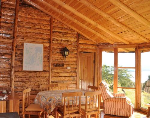 a dining room with a table and chairs in a cabin at Mallin Colorado Ecolodge in Aldana