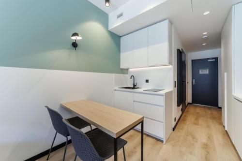a kitchen with a wooden table and two chairs at River Stay Apartments in Tallinn