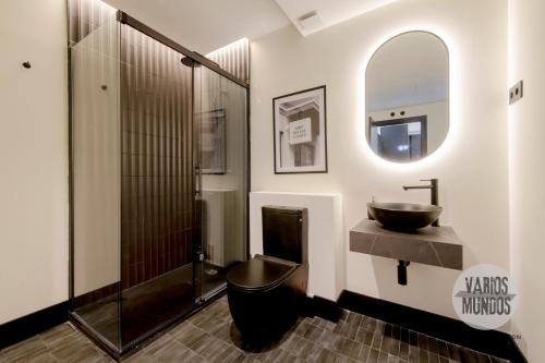 Un baño con lavabo, inodoro y espejo. en Bright Apt para 4pax en Gran Via-Plaza de Carmen E2, en Madrid