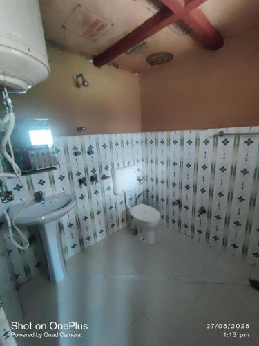 a bathroom with a sink and a toilet at Moti classic deep forest in Kasol
