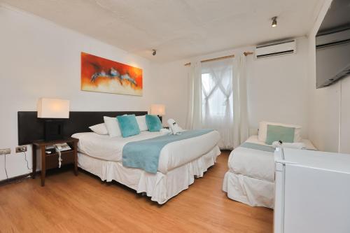 a hotel room with two beds and a window at Hotel Boutique Trinidad in Viña del Mar