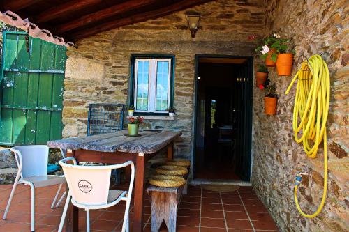 a stone house with a table and chairs on a patio at Casa de Cotas in Cotas