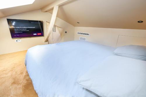 une chambre avec un lit blanc et une télévision à écran plat dans l'établissement 3mn Monaco - Cosy duplex rénové - DL, à Beausoleil