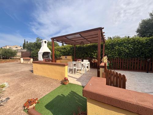 a garden with a pavilion and a table and chairs at Mariella House in Fasano