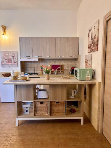 a kitchen with wooden cabinets and a counter top at Mariella House in Fasano