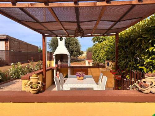 a patio with a table and chairs and a grill at Mariella House in Fasano