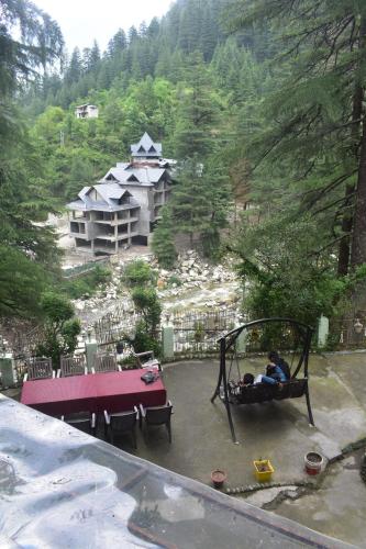 a person sitting in a swing in a yard at Moti classic deep forest in Kasol