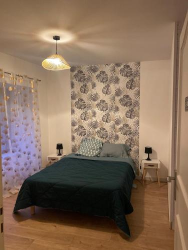 a bedroom with a bed with a green bedspread at Appartement à la campagne in Flavin