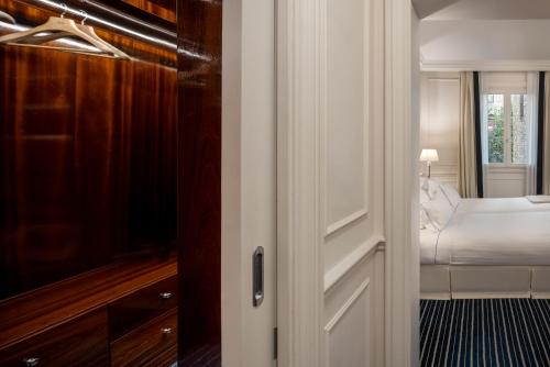 a room with a bedroom with a bed and a door at Hotel Lungarno - Lungarno Collection in Florence