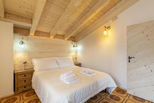 a bedroom with a white bed with towels on it at Garden Apartment Relax in Barco