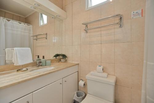 a bathroom with a toilet and a sink and a mirror at Hotel Boutique Trinidad in Viña del Mar