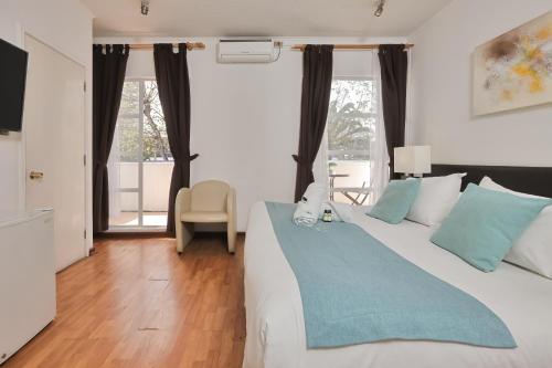 a bedroom with a large bed with a blue blanket at Hotel Boutique Trinidad in Viña del Mar