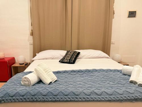 a bed with a blue blanket and pillows on it at Luxury 5BR , 4BA Penthouse In the City Center in Cagliari