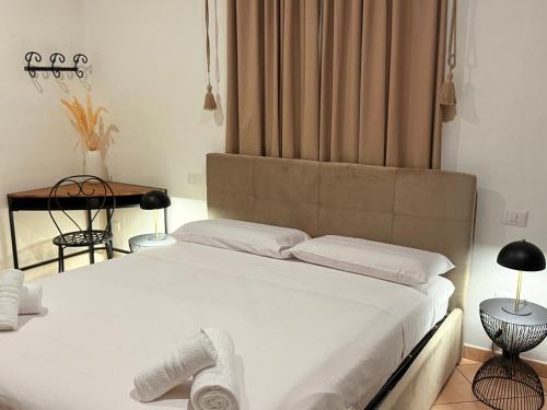 a bedroom with a large white bed with towels on it at Luxury 5BR , 4BA Penthouse In the City Center in Cagliari