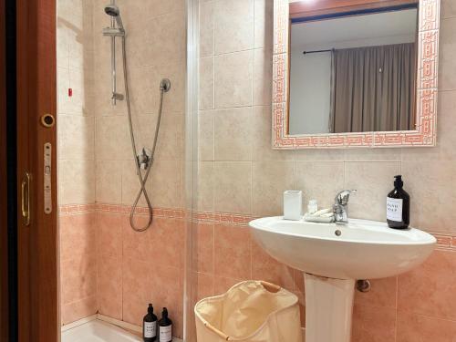 a bathroom with a sink and a shower with a mirror at Luxury 5BR , 4BA Penthouse In the City Center in Cagliari