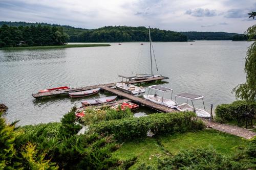 a group of boats docked at a dock on a lake at Tawerna Kaszubska in Ostrzyce